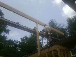 Carpenter setting a ridge beam over a new addition frame — Ice Dam Removal by Roofing Brothers in Iona