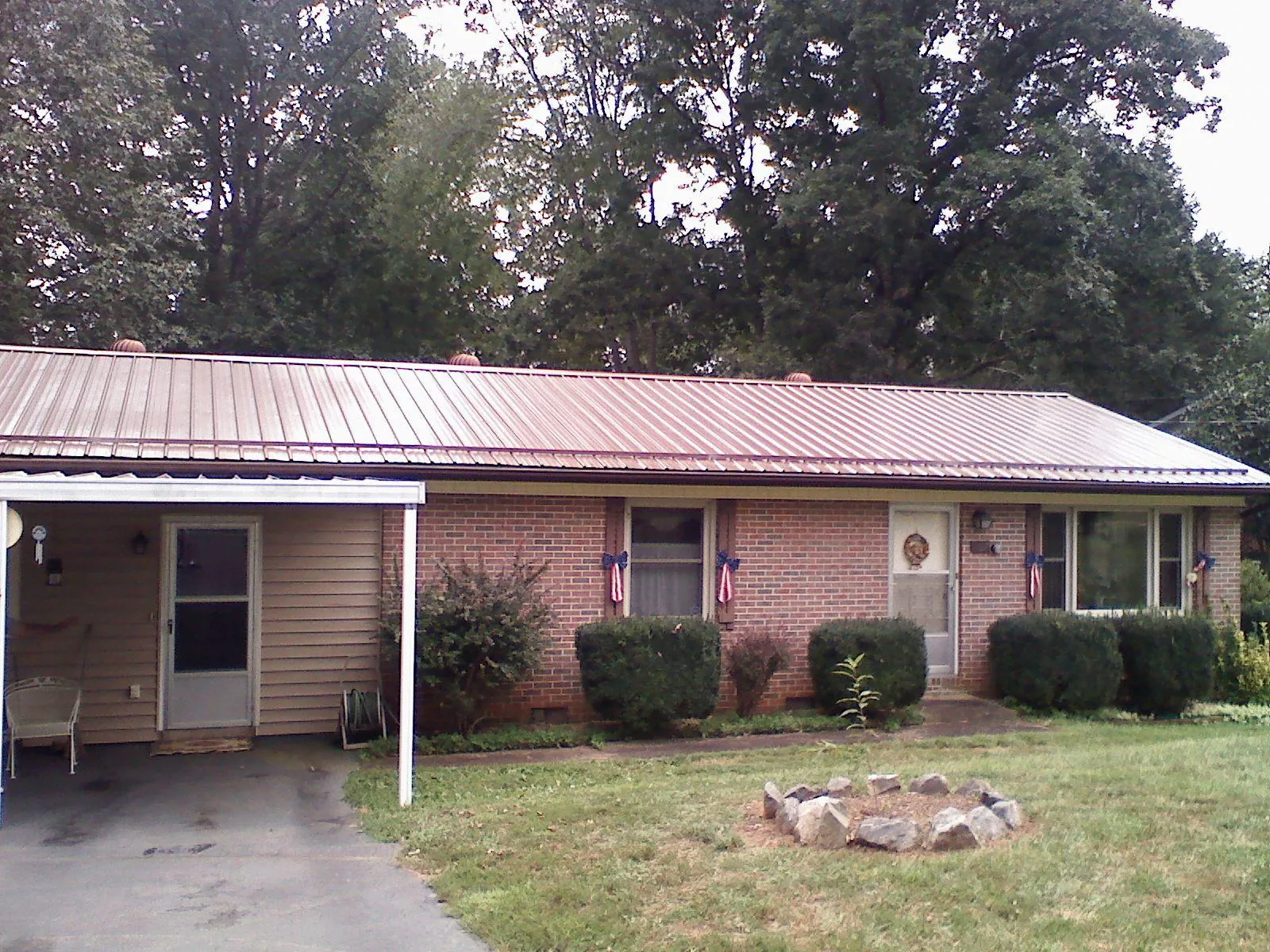 Bronze metal roof and carport on a brick ranch home — Roof Repair work by our crew in Iona